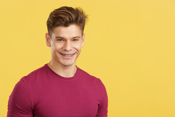 Caucasian man smiling while wearing brackets on his teeth