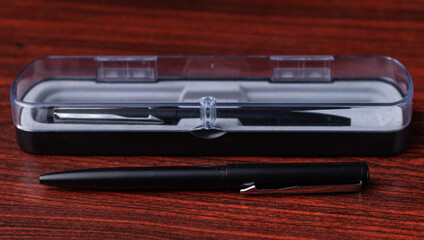 Kit of two metal premium pens with a clear plastic box on a wooden surface 