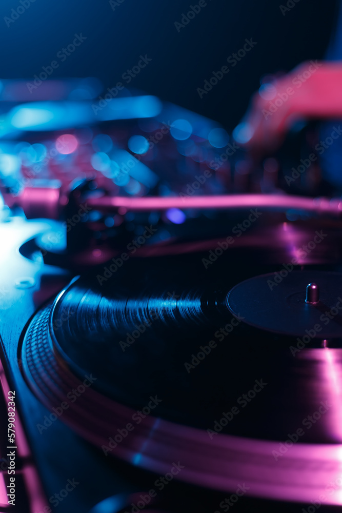 Wall mural DJ turntable playing vinyl record with music on hip hop party in night club