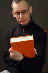 a person holding a thick orange book
