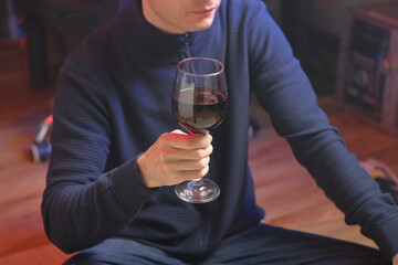 person holding a glass of wine while sitting cross-legged