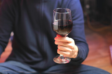 person holding a glass of wine while sitting