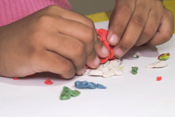 Children's hands playing with colorful plasticine. Concept of school, educational activities, happy childhood.