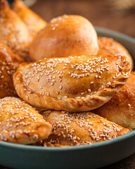 Portion of assorted uzbek baked samsa pies with sesame