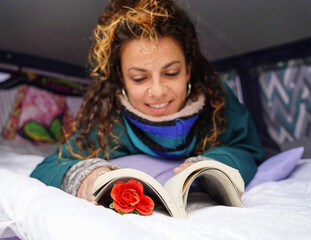 Lying woman with a rose reading a book. Catalonia Independence Day. Sant jordi day.