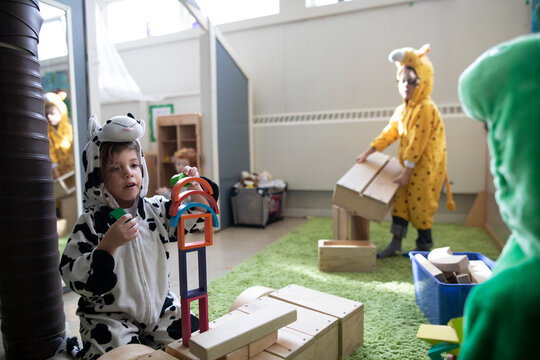 Preschool Boys In Costumes Playing With Wood Blocks