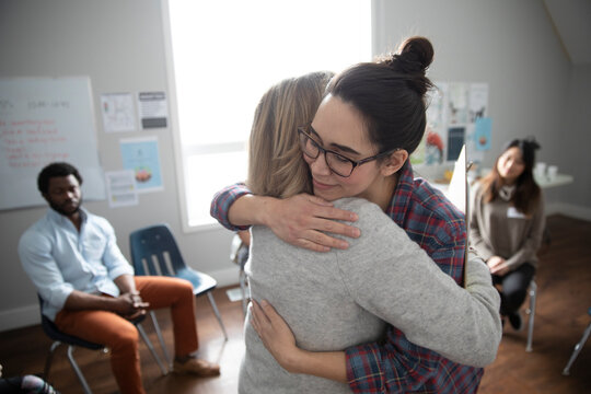 Women hugging in support at support group in community center