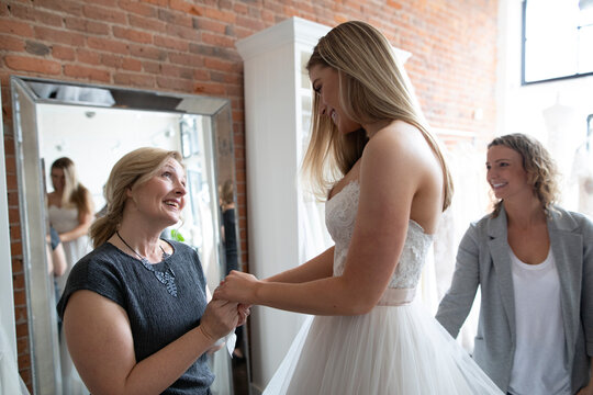 Affectionate bride and mother at wedding dress fitting
