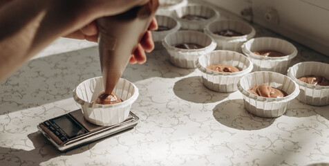 Fototapeta na wymiar Chocolate muffins. Homemade chocolate muffins. The process of making homemade chocolate cupcakes with whipped cream.