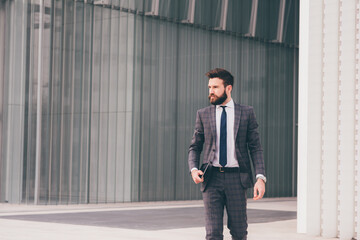 Confident and professional elegant bearded businessman walking outdoor