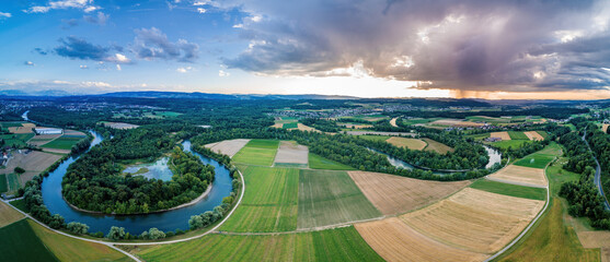 Fototapeta na wymiar Panorama der Reuss mit ihren Schlaufen im Gebiet Bremgarten-Eggenwil. Dramatischer Himmel mit einer aufziehenden Gewitterfront.