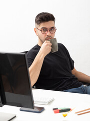 Young man working and drink coffee in his home office.education.business.e-commerce