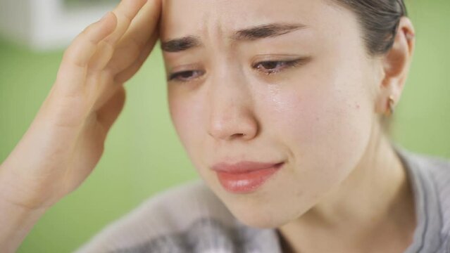 Depressed asian young woman crying, having a crying crisis.
Unhappy and sad young asian woman crying, unable to control her anger, feeling emotional.
