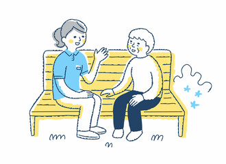 ベンチに座って話すシニア女性と介護スタッフ