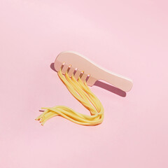 Cooked spaghetti and hair comb, creative aesthetic layout, hair care idea. 