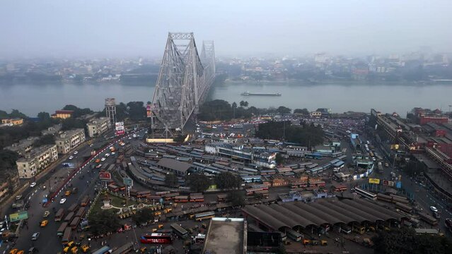 Aerial view of architectural landmark Howrah Bridge and Howrah Railway Station on a smoggy day in Kolkata, West Bengal, India. Kolkata is one of the world's most polluted cities.
