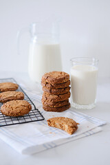 A stack of delicious homemade cookies with a glass of milk on the background