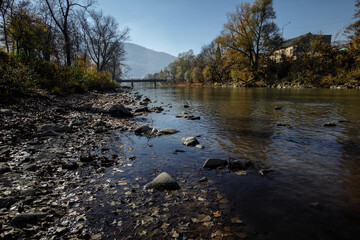 A mountain river flows in the middle of the city on a sunny day