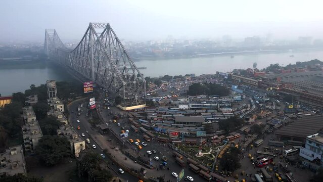 Aerial timelapse view of architectural landmark Howrah Bridge and Howrah Railway Station on a smoggy day in Kolkata, West Bengal, India. Kolkata is one of the world's most polluted cities.