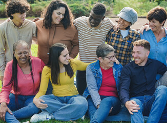 Fototapeta premium Group of multi generational people having fun together at city park - Multiracial friends outdoor