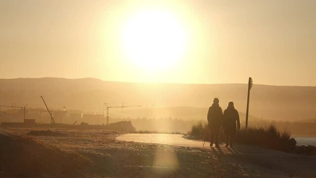 An elderly couple walking under morning sun slow motion Reykjavik Iceland