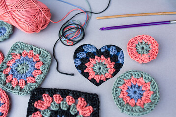 Closeup of crochet pattern in a heart, two hooks, other patterns