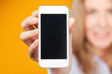 Happy young woman hold phone with a blank screen
