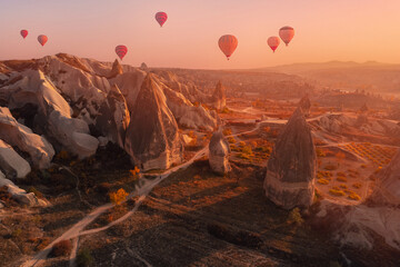 Autumn landscape Cappadocia hot air balloons and stone old cave house in Goreme national park Turkey, aerial top view. Travel landmark trip concept