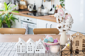 Key to house of cozy home with Easter decor with rabbit and eggs on table of kitchen. Building, design, project, moving to new house, mortgage, insurance, rent and purchase real estate