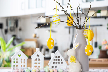 Key to house of cozy home with Easter decor with rabbit and eggs on table of kitchen. Building, design, project, moving to new house, mortgage, insurance, rent and purchase real estate