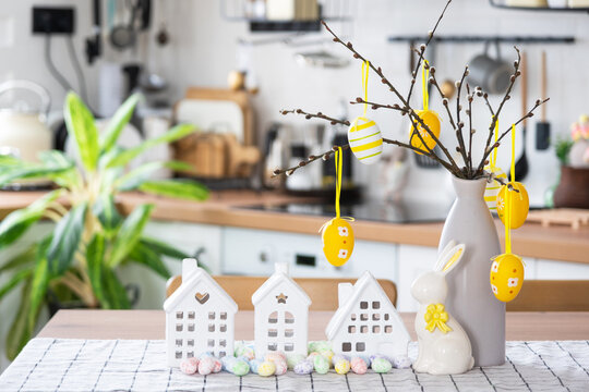 Key to house of cozy home with Easter decor with rabbit and eggs on table of kitchen. Building, design, project, moving to new house, mortgage, insurance, rent and purchase real estate