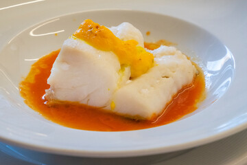 Confit cod dish with baked in a white dish.
