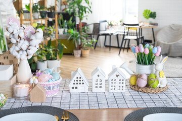 Key to house of cozy home with Easter decor with rabbit and eggs on table of kitchen. Building, design, project, moving to new house, mortgage, insurance, rent and purchase real estate