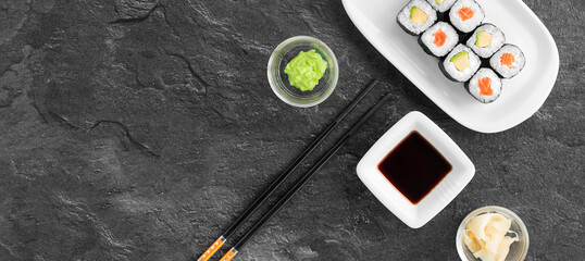 Tablet mit Sushi, Wasabi, Sojasoße und Essstäbchen