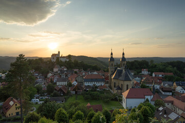 Burg Gössweinstein auf Hügel in Franken und Bayern mit Dorf zum Sonnenuntergang.