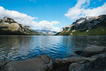 Lake Minnewanka in Alberta, Canada on a cloudy day with stunning mountains and water reflections