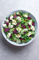 Light, summer salad with goat cheese, beetroot pieces, walnuts, olive oil and herbs. Mediterranean salads, typical dishes of Spain, France, Turkey and Italy