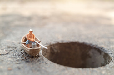 Miniature fishermen are fishing by boat