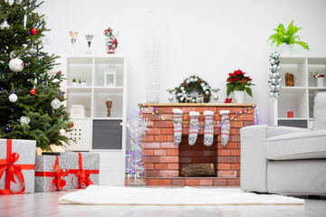 Room with Christmas decorations and brick fireplace with wood.