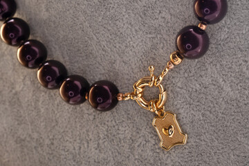 author beautiful  blackberry color pearls necklaces with heart pendant demonstrated on maneken. fashion and jewelry concept