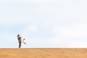 Couple hugging on wooden floor with blue sky background