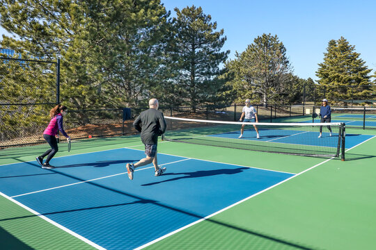 Men and Women in a Doubles Game of Pickleball