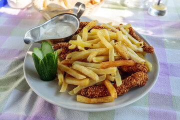 French fries with breaded chicken nuggets and sauce served in Sutomore, Montenegro