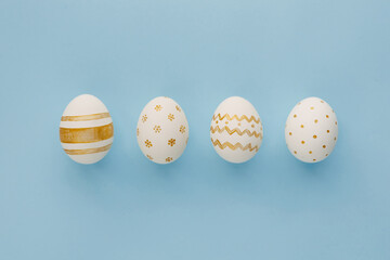 Easter background. Easter golden decorated eggs on blue background. Minimal easter concept. Flat Lay of Golden Easter Eggs