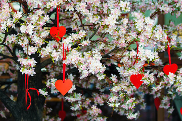 Fototapeta na wymiar Artificial tree with flowers and paper hearts