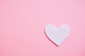 White fabric heart on pale pink table