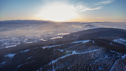 Obraz premium A bird's eye view of snowy Liberec at sunrise. Photographed on Jested Ridge by drone in winter.
