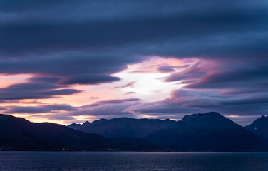 Bergige Landschaft bei Sonnenaufgang - Wolkenbedeckter mystischer Himmel über einer Bergkette in Norwegen - Troms og Finnmark