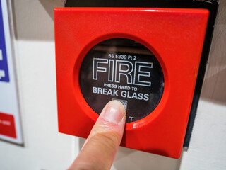 A red MCP or fire alarm manual call point button. Break glass to activate the alarm. Concept for fire health and safety, fire, warning, emergency, danger and rescue.