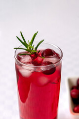 Cranberry juice in a glass on a table with a white tablecloth